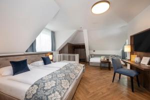 een slaapkamer met een bed, een bureau en een stoel bij Salzburg Hotel Lilienhof in Salzburg