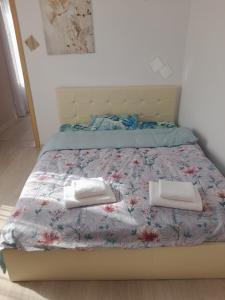 a bed with two white towels on top of it at 3 Room Penthouse Apartment with fantastic Seaview and big Terraces OASIS Ravda in Ravda