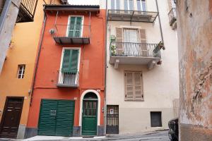 un edificio naranja con puertas y ventanas verdes en Lori's Inn 2 Appartamenti Mondovì, en Mondovì