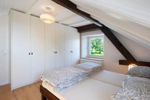 a attic bedroom with two beds and a window at Quellenhof Südschwarzwald in Murg