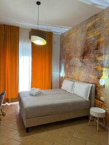 1 dormitorio con 1 cama con pared de color naranja en Le Corti del Re en Nápoles