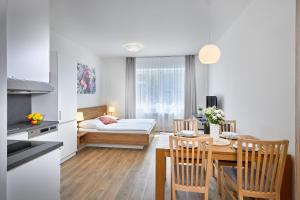 a kitchen and living room with a table and a bed at DownTown Suites Belohorska in Prague