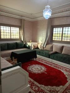 a living room with a couch and a red rug at Riad Nasma Souihla in Marrakesh
