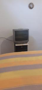 a tv sitting on a stand next to a bed at Casa campestre en una comunidad ancestrar bajo las faldas del Taita Imbabura in San Juan de Ilumán