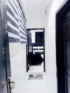 um corredor com uma porta que leva a um quarto em blueocean.cog Apartments em Benin City
