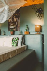een bed in een kamer met een schilderij aan de muur bij CASA MiA in Moreré