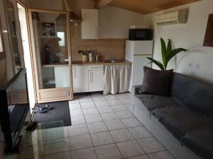 a living room with a couch and a kitchen at Le mazet in Poussan