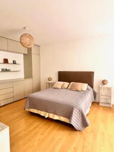 1 dormitorio con 1 cama y suelo de madera en Ocio Laprida en Buenos Aires