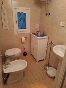 a bathroom with two toilets and a sink at la casina della bubbolina in Semproniano