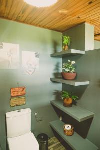 een badkamer met een toilet en een aantal planten aan de muur bij CASA MiA in Moreré