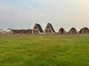 una fila de casas en un campo de hierba en Buru Resort en Ghātsīla