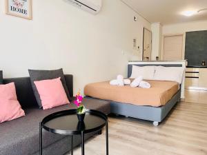 um quarto com uma cama e um sofá com uma mesa em Elvita Apartments 4 em Atenas