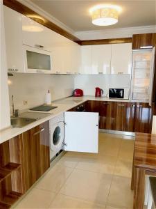 - une cuisine avec des placards blancs et un lave-linge/sèche-linge dans l'établissement Private Super apartments by sea in Apart Hotel !, à Pomorie