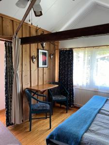 1 dormitorio con mesa, 2 sillas y 1 cama en Drei Jahreszeiten en Bredsatra