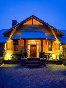 a wooden house with a front porch with a door at The Pine Court Luxury Resort in Bhurban