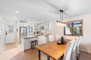 a kitchen and dining room with a wooden table and chairs at Spacious Condo with Lake and Mountain View in Mont-Tremblant +15 photos