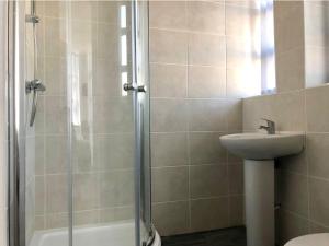 uma casa de banho com um chuveiro e um lavatório. em Fabrik: Winter Gardens Service Apartments 2 em Blackpool