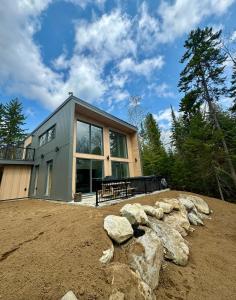 una casa su una collina con delle rocce davanti di Le Grand Pic Foyer Spa & plaisir a Saint Come