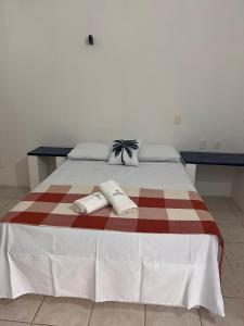 uma cama com duas almofadas em cima em Pousada Palamós Uruaú em Beberibe