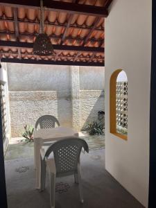 uma mesa e duas cadeiras sob um telhado em Pousada Palamós Uruaú em Beberibe