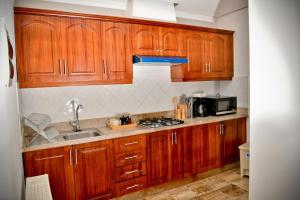 a kitchen with wooden cabinets and a sink at White Sands Punta Cana - Pool-Jacuzzi in Punta Cana