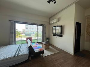 a bedroom with a bed and a flat screen tv at Come Home Travel in Tainan