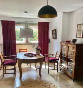 ein Wohnzimmer mit einem Tisch, Stühlen und einem Fenster in der Unterkunft 1 - 2 Zimmer in historischem Altstadthaus in Freudenstadt