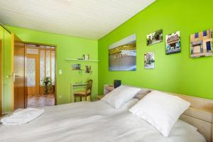 una camera da letto con pareti verdi e un letto con cuscini bianchi di Weiler in den Bergen a Schwäbisch Gmünd