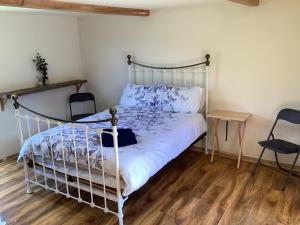 a bedroom with a white bed and a wooden floor at Cabin 4 in Kent