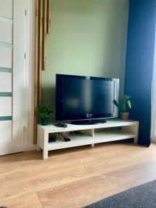 a flat screen tv sitting on a white entertainment center at Chillout Airport Apartment KL33 - Free parking in Warsaw
