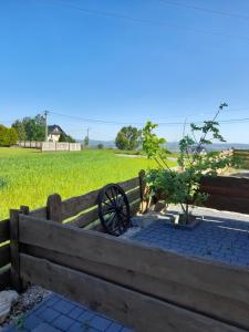 a wooden fence with a wooden wheel next to a tree at Apartamenty przy szlaku in Krajno Pierwsze
