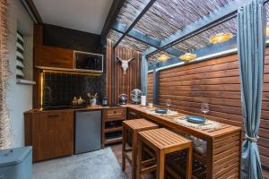 a kitchen with wooden cabinets and a counter with stools at Coco Lagon accès plage in Saint-Paul