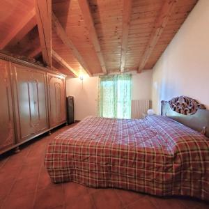 ボッシコにあるIl nido in montagna Mountain Lake Iseo Hospitalityのベッドルーム1室(チェック入りの毛布付きのベッド1台付)
