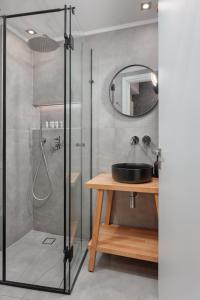 a bathroom with a shower with a sink and a mirror at Hypnos Cozy Living in Ioannina