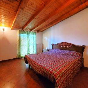 ボッシコにあるIl nido in montagna Mountain Lake Iseo Hospitalityのベッドルーム1室(チェック入りの毛布付きのベッド1台付)