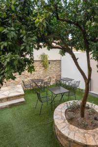 een groep tafels en stoelen onder een boom bij Hypnos Cozy Living in Ioannina