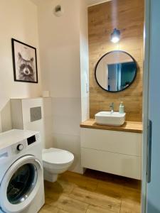a bathroom with a washing machine and a sink at Chillout Airport Apartment KL33 - Free parking in Warsaw