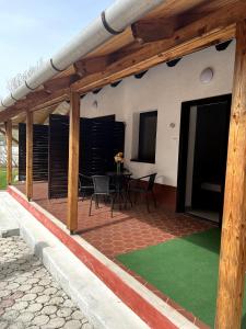 a covered patio with a table and chairs on it at Aniiza Apartman 2 in Örvényes