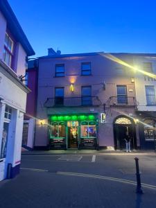 a store with green lights in front of a building at Number One - Townhouse in Kinsale