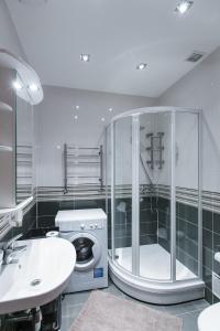 a bathroom with a shower and a sink and a washing machine at Riga Lux Apartments - Ernesta, Free parking in Rīga