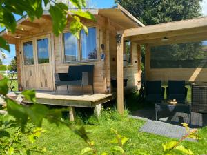 a tiny house with a porch and a table and chairs at Caravane Ruby 