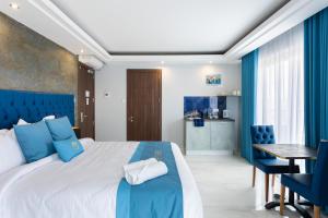 Schlafzimmer mit einem blauen und weißen Bett und einem Tisch in der Unterkunft THE OSiRiS in Marsaxlokk