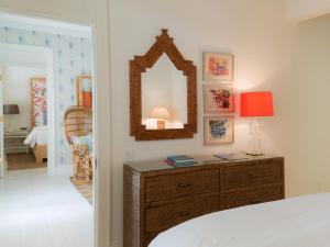 1 dormitorio con 1 cama y vestidor con espejo en Eleven Bahama House, en Harbour Island