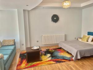 a bedroom with a bed and a couch and a rug at White Rose Guest Rooms in Burgas