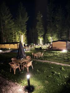 a group of picnic tables in a field at night at Infinity Villa and Resort Kumrat Valley in Tāl