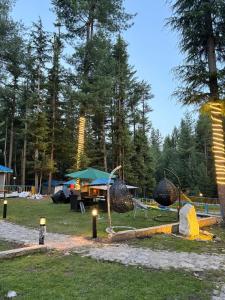 un parque con mesa de picnic y sombrilla en Infinity Villa and Resort Kumrat Valley, en Tāl