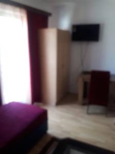 um quarto com uma cama e uma televisão de ecrã plano em Apartman Break 2 em Bijeljina