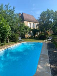 una piscina blu davanti a una casa di Choubello Gite classé 4 étoiles a Fajoles