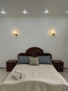 1 dormitorio con 1 cama grande y 2 almohadas en K7 Family 1комнатная квартира en Atyraū