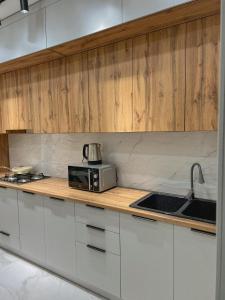 una cocina con fregadero y microondas en una encimera en K7 Family 1комнатная квартира, en Atyraū